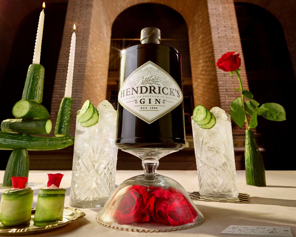 Hendricks Original Gin am Tisch mit Gurke und Rose