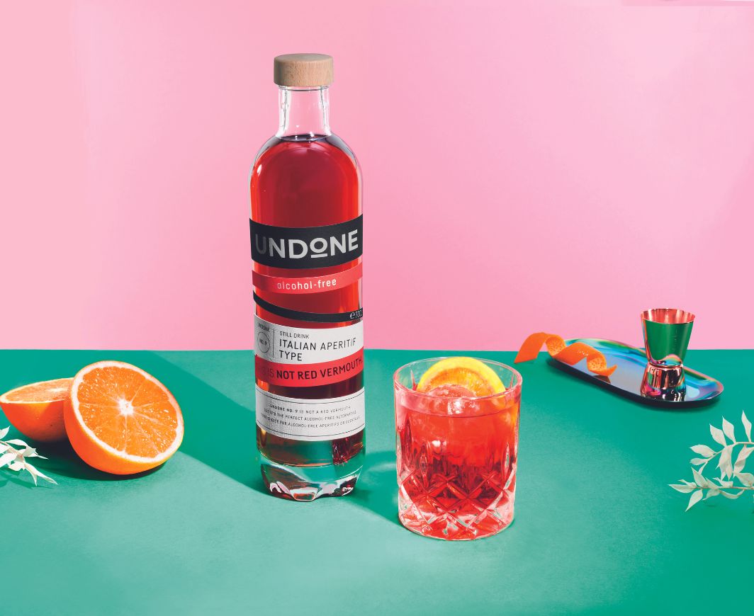 Undon not red Vermoith Flasche mit Negroni Drink for pink-grünem Hintergrund