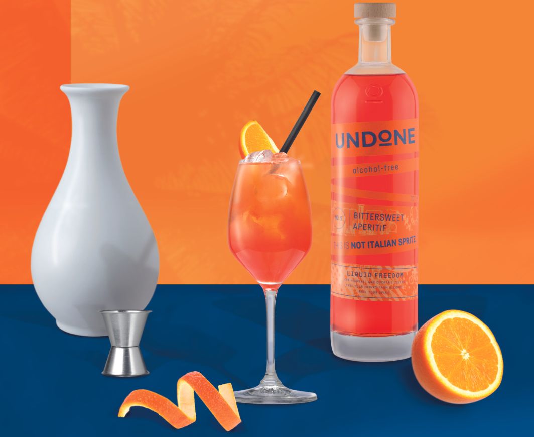Undone not Italian Spritz mit Drink vor orange-blauen Hintergrund