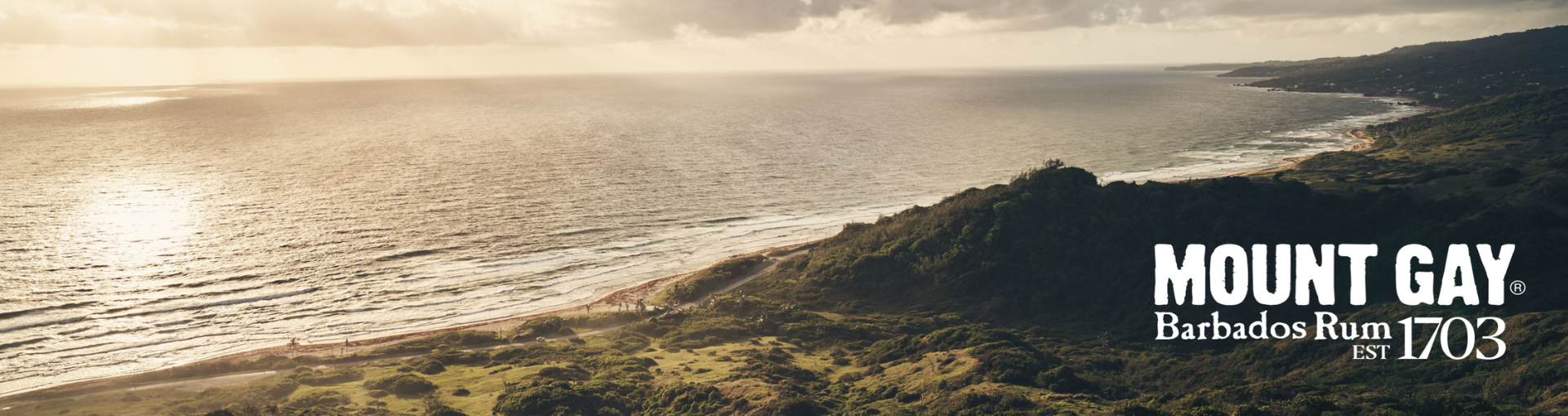 Foto einer Insel mit Küstenlinie, rechts unten der Text "Mount Gay Barbados Rum 1703"