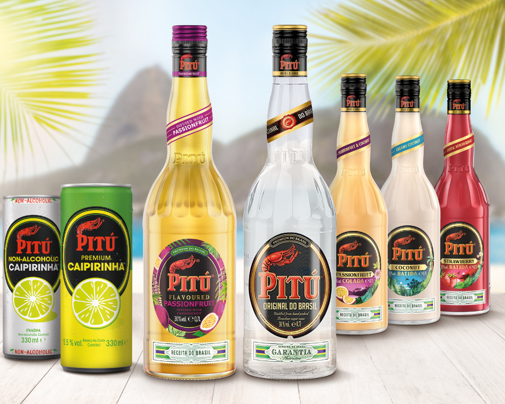 7 Flaschen diverser Pitu Getränke auf einem Holzbrett vor einer Inselkulisse
