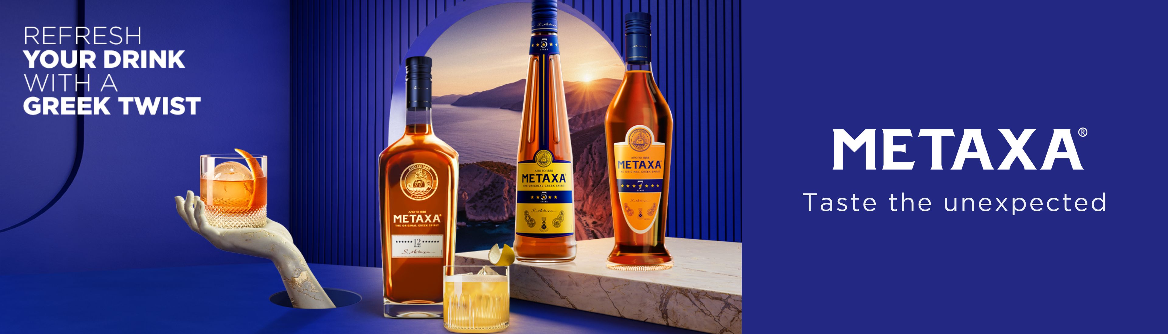 Metaxa Flaschen vor blauer Wand mit Blick durch dem Fenster zum Sonnenuntergang