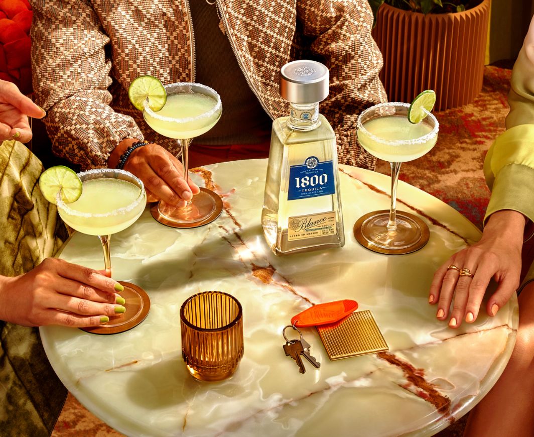 1800 Tequila Magarita mit drei Personem an einem runden Tisch