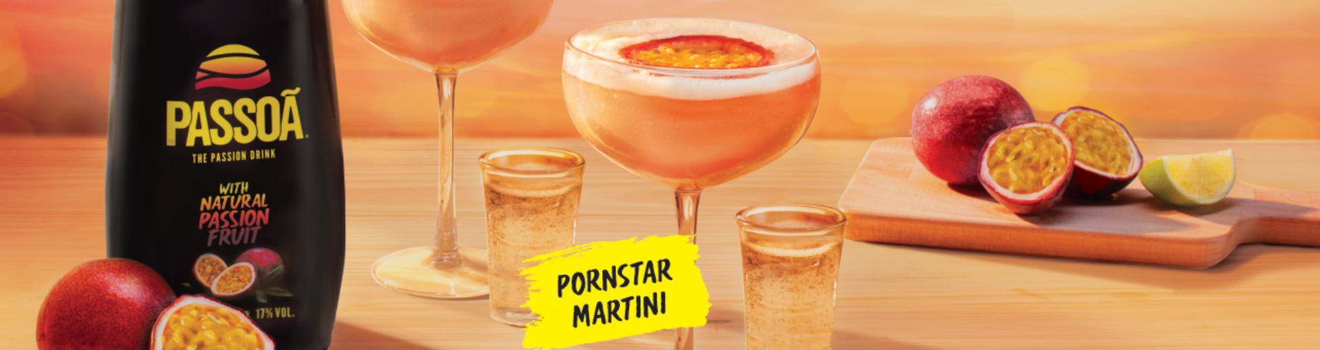 Passoa und zwei Gläser mit Pornstar Martini vor orangenem Hintergrund