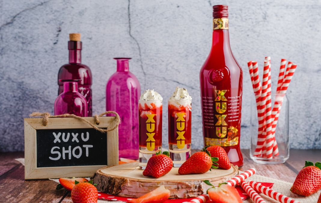 XUXU Flasche und Shots auf einem isch mit Erdbeeren