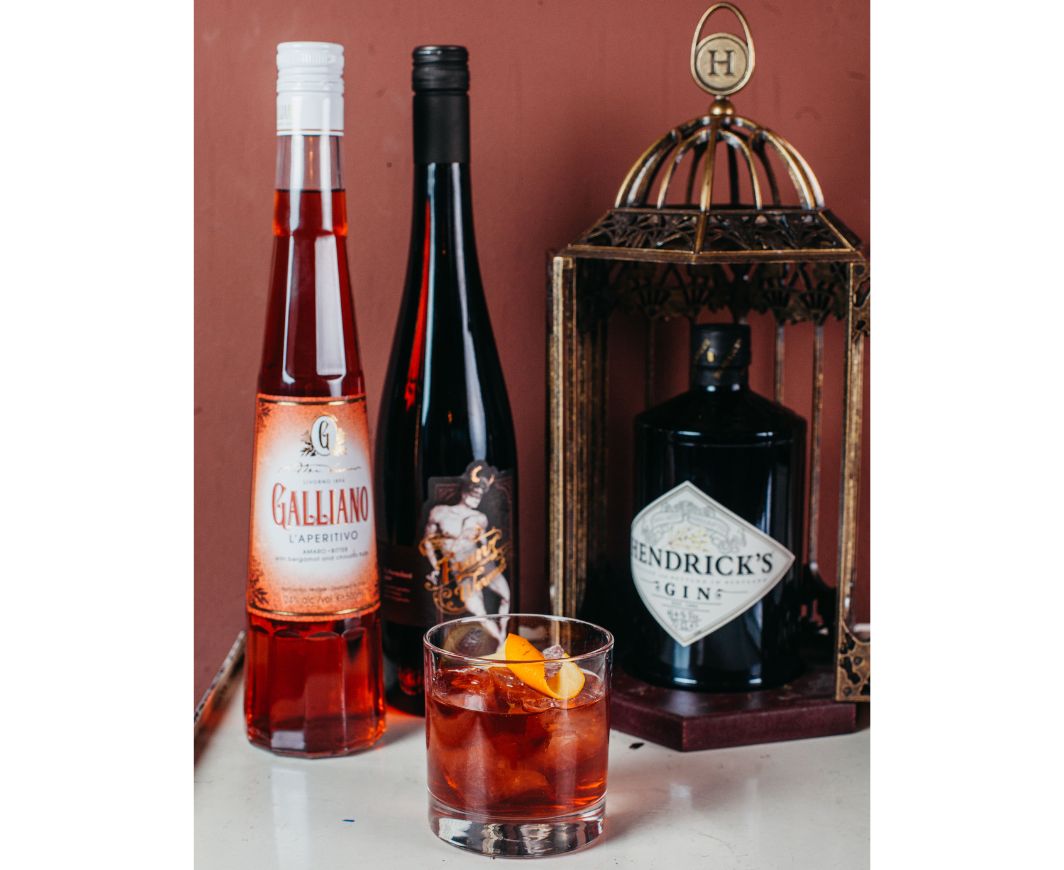 Negroni Cocktail im Tumblerglas mit Flaschen