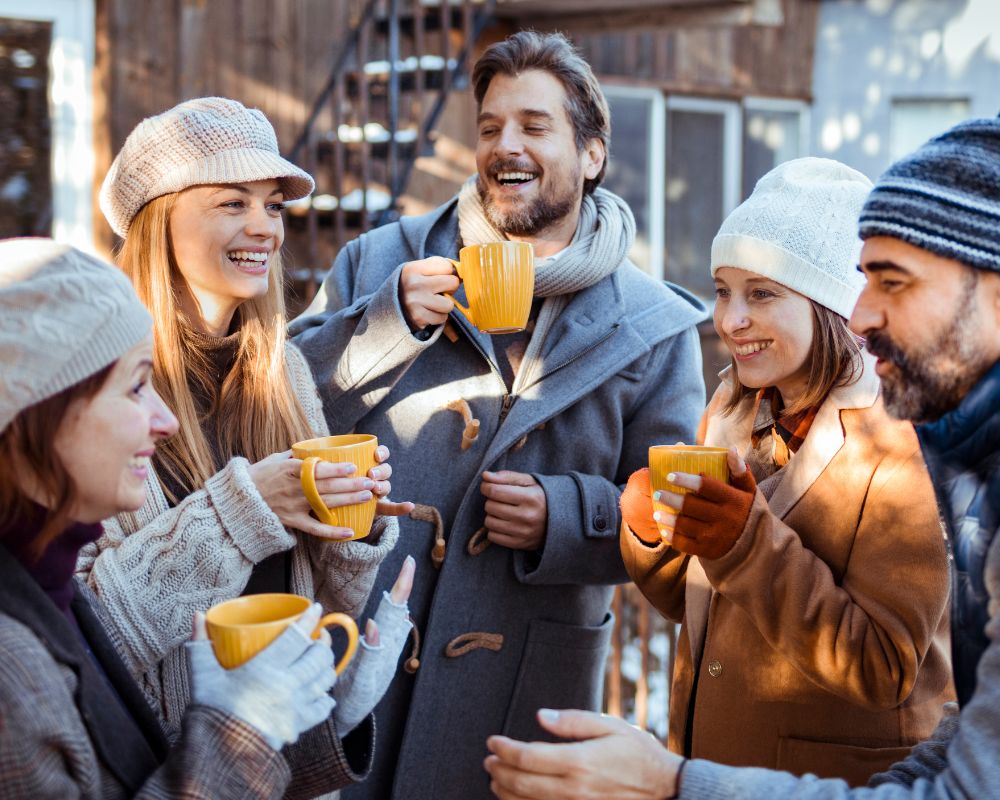 Fünf Freunde trinken im Winter Punsch aus Kermikbecher